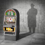 gambling-concept-ludomania-slot-machine-cast-shadow-in-form-gangster-picture-id944519472